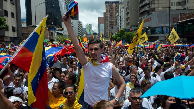 Opposition supporters hold Venezuelan flags and sing the national anthem during a protest in Caracas on Thursday.