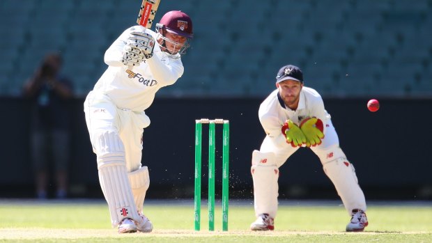 Class act: Queensland batsman Usman Khawaja drives as Victorian wicketkeeper Matthew Wade looks on during day one of the Sheffield Shield match at the MCG.