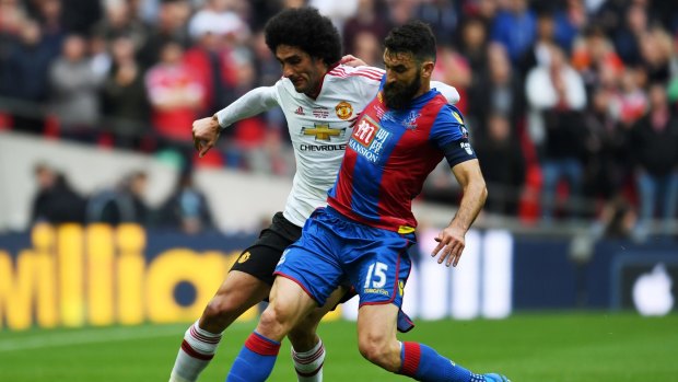 Competing for possession: Manchester United star Marouane Fellaini and Socceroos skipper Mile Jedinak, of Crystal Palace, get in a tangle during the FA Cup final at Wembley Stadium.