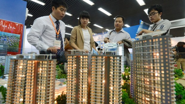 People view a model of a property development in Beijing.