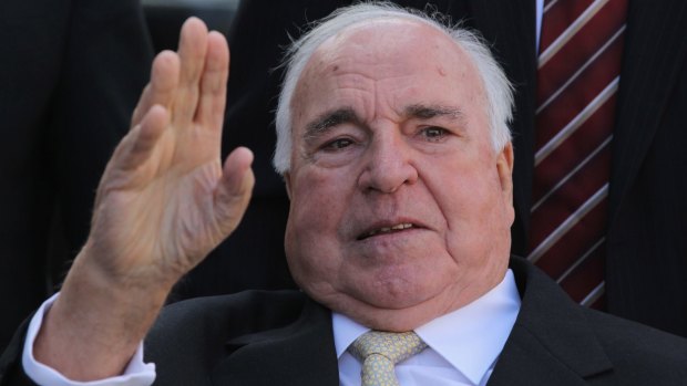 Former German Chancellor Helmut Kohl waves at supporters from his wheelchair in 2010.