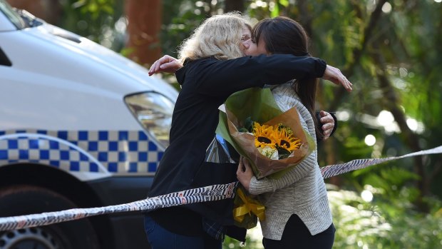 A woman with flowers embraces Faye Leveson (left), Matthew Leveson's mother, on Friday.
