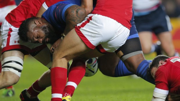 Mathieu Bastareaud is taken down by three Canada defenders.