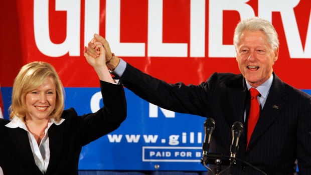 Former president Bill Clinton holds up the hand of Kirsten Gillibrand, at a rally in 2006.