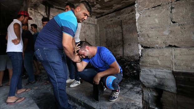 Iraqi men grieve at the scene of the deadly suicide bombing in Baghdad.