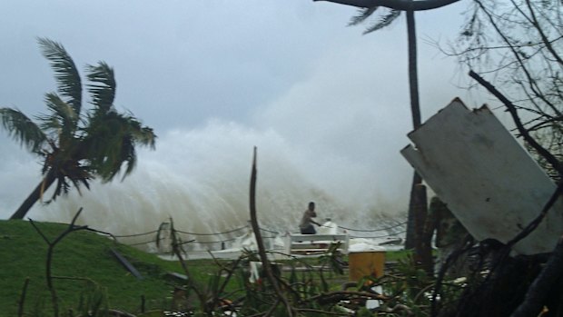 A man running away from high waves caused by Cyclone Pam crashing along the coast in the Vanuatu capital of Port Vila. 