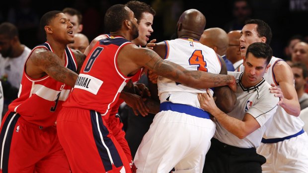 Not so festive: Officials break up a scuffle between Quincy Acy #4 of the New York Knicks and John Wall #2 of the Washington Wizards in the second half of their game at Madison Square Garden on December 25, 2014 in New York City. 