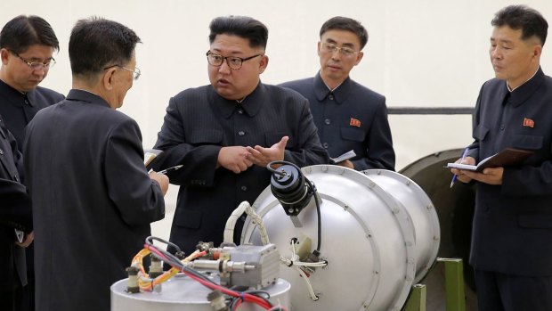 North Korean leader Kim Jong-un at an undisclosed location examines an explosive device.