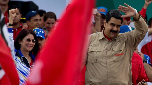 Venezuela's President Nicolas Maduro, right, and his wife Cilia Flores greet supporters at a rally in Caracas on Saturday.