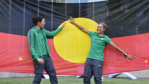 Proud players: Lydia Williams and Kyah Simon with their giant Aboriginal flag in Canada.