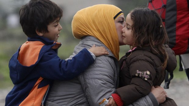 A family hugs as they arrive at the transit camp for refugees in Macedonia, after crossing from Greece. Several thousand people cross that border daily on their way through the Balkans towards the more prosperous EU countries. 