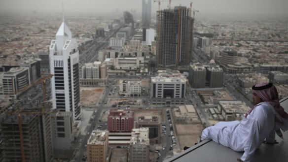 A man sits on a ledge high up on the Al Faisaliyah Centre tower in Riyadh, Saudi Arabia.