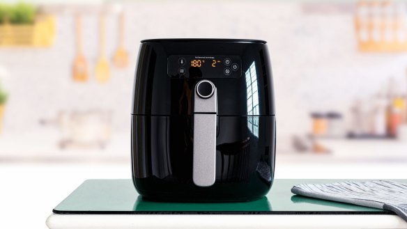 A simple kitchen gadget standing in front of a boy, asking him to throw something in it.