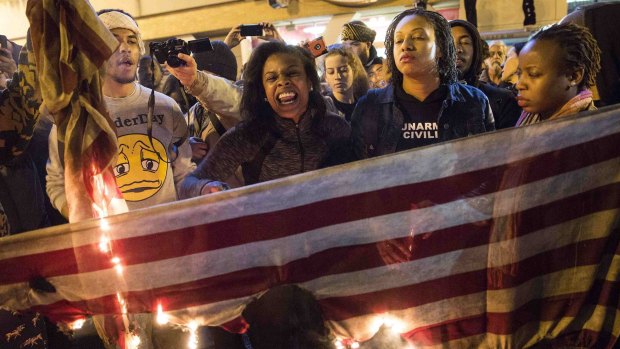 Demonstrators burn the American flag during a "Justice for Mike Brown" march in Washington.