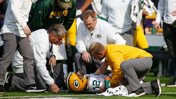 Green Bay Packers quarterback Aaron Rodgers is attended to by medical staff.