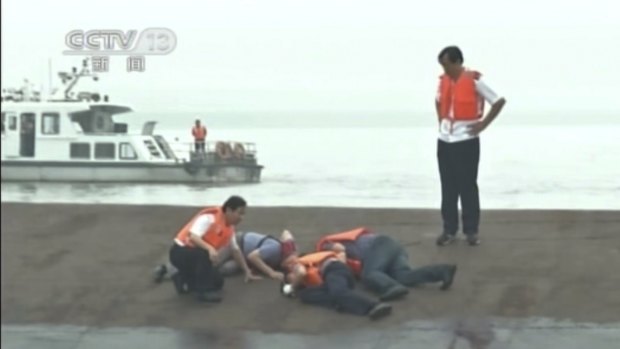 Rescue workers listen for a response to their tapping on the hull of a capsized ship on the Yangtze River.