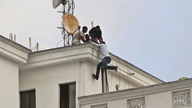 Popular hotel attacked by Islamist militants: Guests make their ways to the roof as they escape from Maka Al-Mukarama hotel.