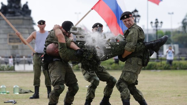 A Russian Marine uses a hammer to break a brick on top of his comrade's stomach during a Capability Demonstration at Manila's Rizal Park.