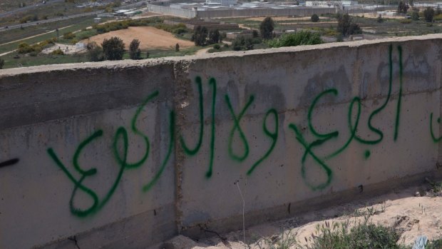 Graffiti in Arabic reads "hunger and not kneeling", on a wall overlooking Israel's Ofer prison in the occupied West Bank.