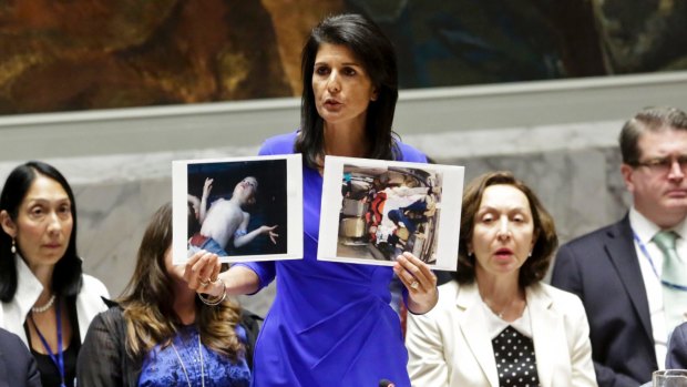 United States' Ambassador to the United Nations, Nikki Haley, holds pictures of Syrian victims.