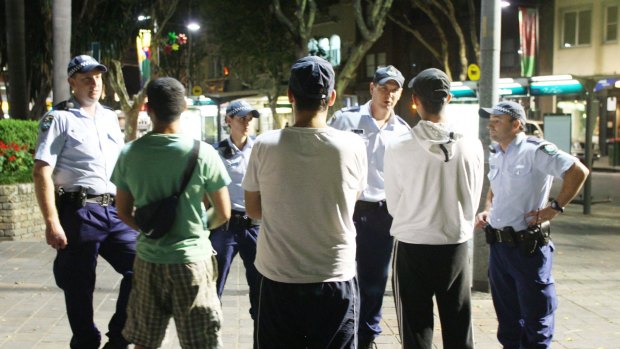 Police speak to a group of men in Kings Cross.