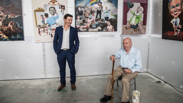 Bald Archy winner James Brennan with his winning painting Anh Can Do (left) and his right another of his paintings 'Penny leading the Way' with Peter Batey, the founding creator of the Bald Archy Prize.