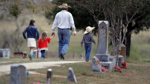 A family arrives for a grave-side service for Richard and Therese Rodriguez at the Sutherland Springs Cemetery.