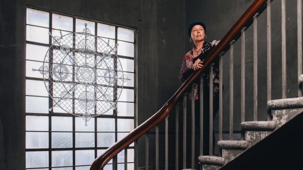 Ngaio Fitzpatrick with her work Glass Mandala on the historic staircase.