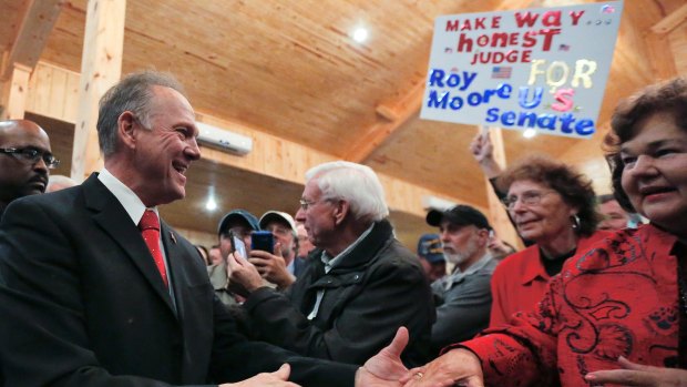 US Senate candidate Roy Moore greets supporters before speaking at a campaign rally on Monday.