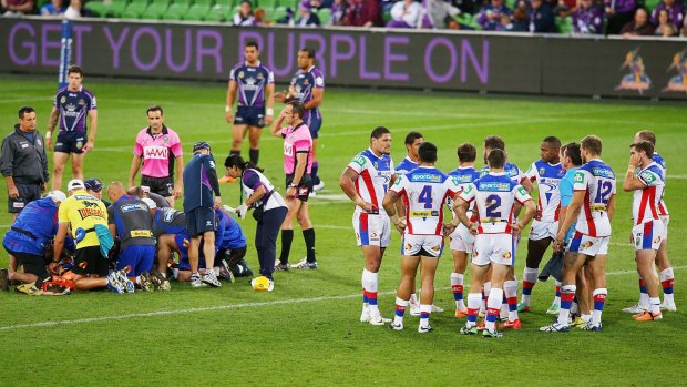 Newcastle Knights, right,  players huddle as Alex McKinnon is treated after the tackle from Jordan McLean that left him a major spinal injury.