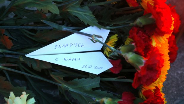 A white paper plane with the writing reading "Belarus is with you" lays among flowers in front of the Russian Embassy in Minsk, Belarus on Sunday. 
