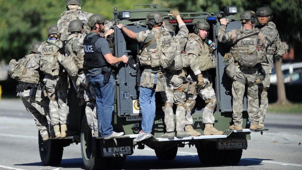 A SWAT vehicle carries police officers near the scene of a shooting in San Bernardino.