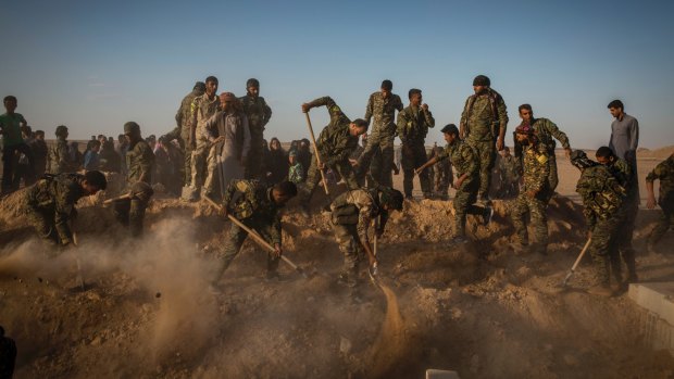 Syrian Democratic Forces militiamen bury a comrade who died fighting  Islamic State militants in the battle for Raqqa.