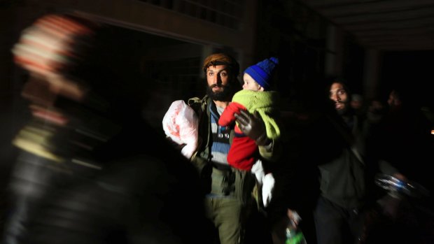 A man and child are evacuated as the UN voted to send monitors into Aleppo. 