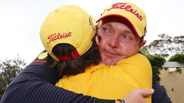 Golfer Jarrod Lyle hugs his wife Briony, after playing the Australian Masters in 2013, his return to golf after beating cancer for a second time.
