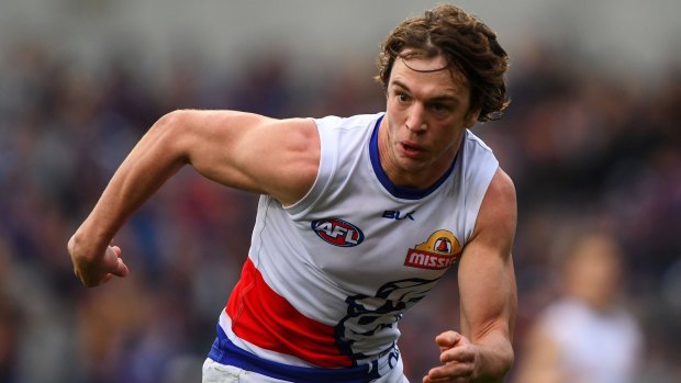 Focused: Liam Picken commits to chasing the ball for the Dogs.