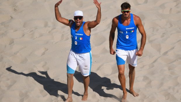 Adrian Carambula,left, and Alex Ranghieri celebrate after defeating Austria in beach volleyball.