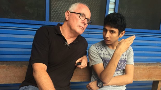 Michael, pictured on assignment talking with a young refugee. 