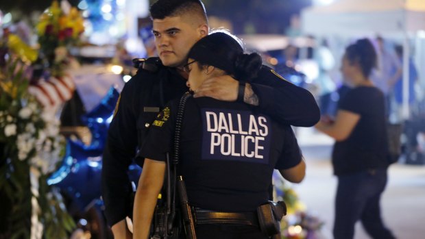 Dallas police officers comfort each other.