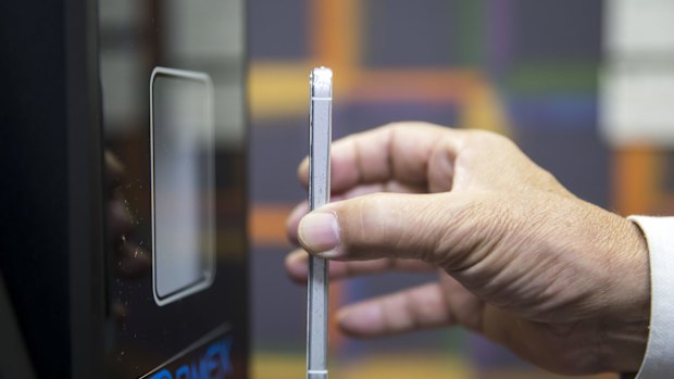 An employee demonstrates using a smartphone to purchase bitcoin from an ATM at the Coin Trader retail store in Tokyo.