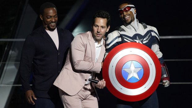 Anthony Mackie, left, and his character Captain America, right, appear on stage with Paul Rudd at the Avengers Campus dedication ceremony at Disney's California Adventure Park.