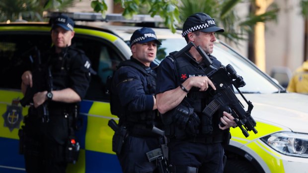 Armed police watch over a vigil in Albert Square, Manchester, on Tuesday.