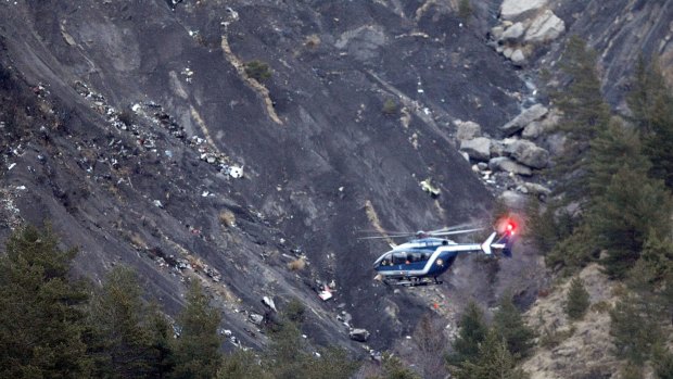 A rescue helicopter flies over debris of the Germanwings passenger jet, scattered on the mountainside, near Seyne-les-Alpes in the French Alps.