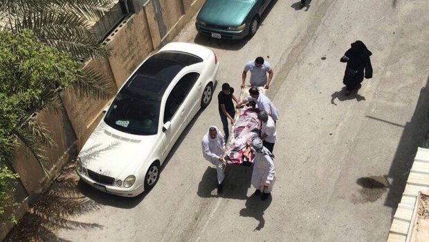 This image provided by an activist who requested anonymity shows people carrying a man injured in a police raid on a sit-in, in Diraz, Bahrain, on Tuesday.
