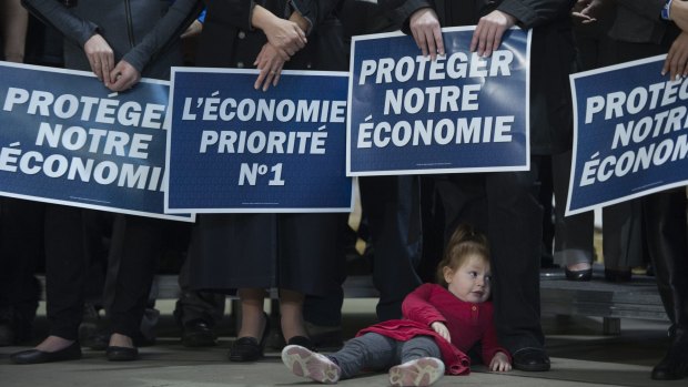 A young girl lies on the ground as Canadian Conservative leader Stephen Harper addresses the crowd at a campaign event in Quebec City on Friday. 
