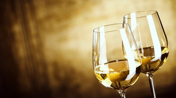 Two glasses of white wine standing side by side.