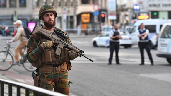 A Belgian Army soldier stands outside Brussels Central Station. While the risk of being caught in a terror attack remains low, the perception of the public - and tourists - is another matter.
