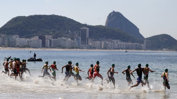 Testing the water: Athletes start the swimming leg of the men's triathlon at the Olympic qualification event on Copacabana beach last month.