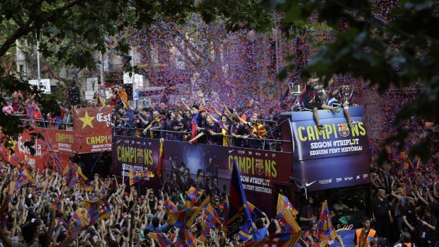 Barcelona players celebrate on the team bus in Barcelona, Spain, after winning the Champions League final on Saturday.