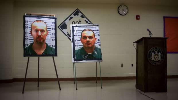 Pictures of escaped prisoners Richard Matt and David Sweat are displayed at a press conference in New York.